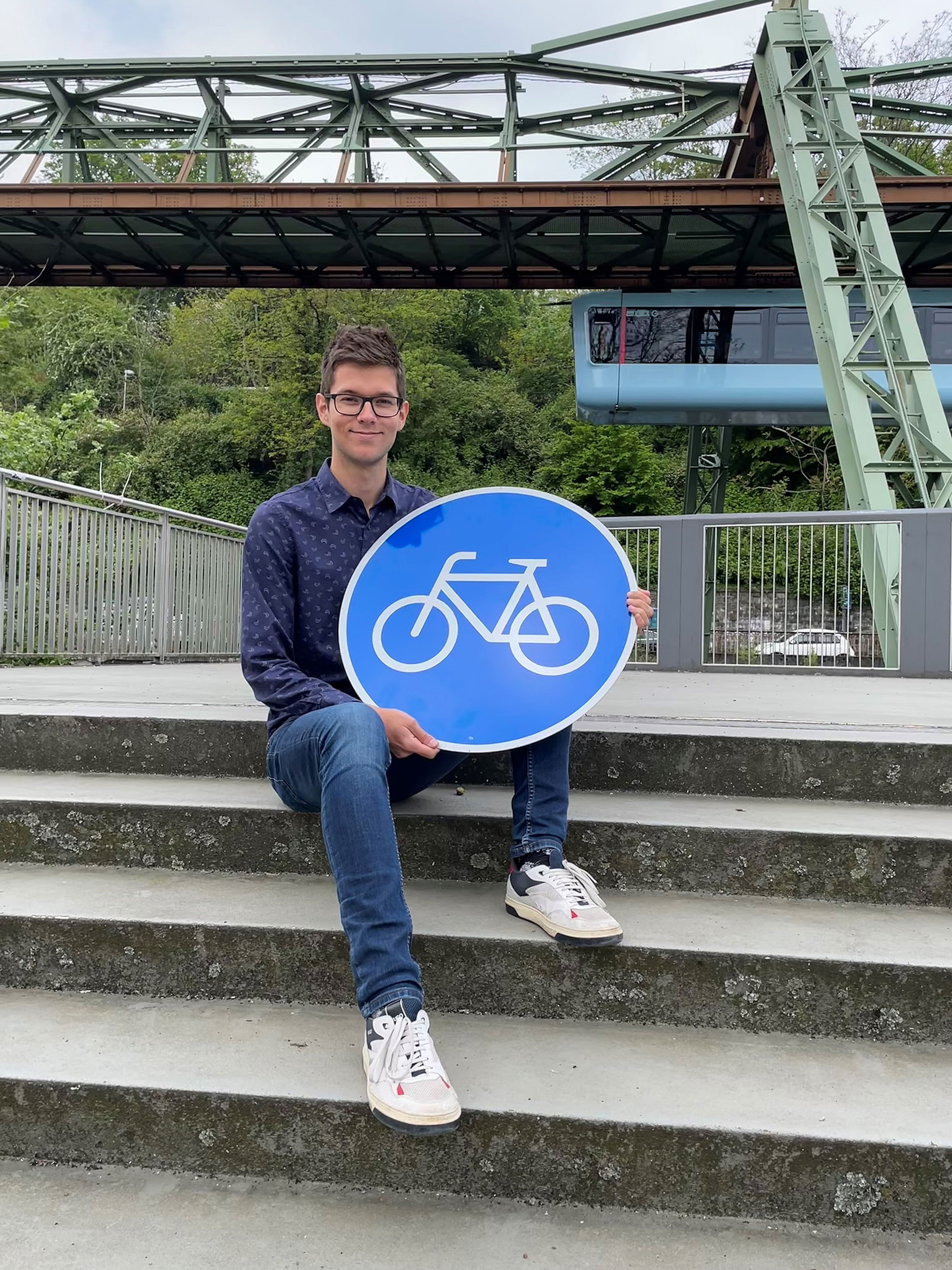 Leonard Arning mit Fahrradweg-Schild